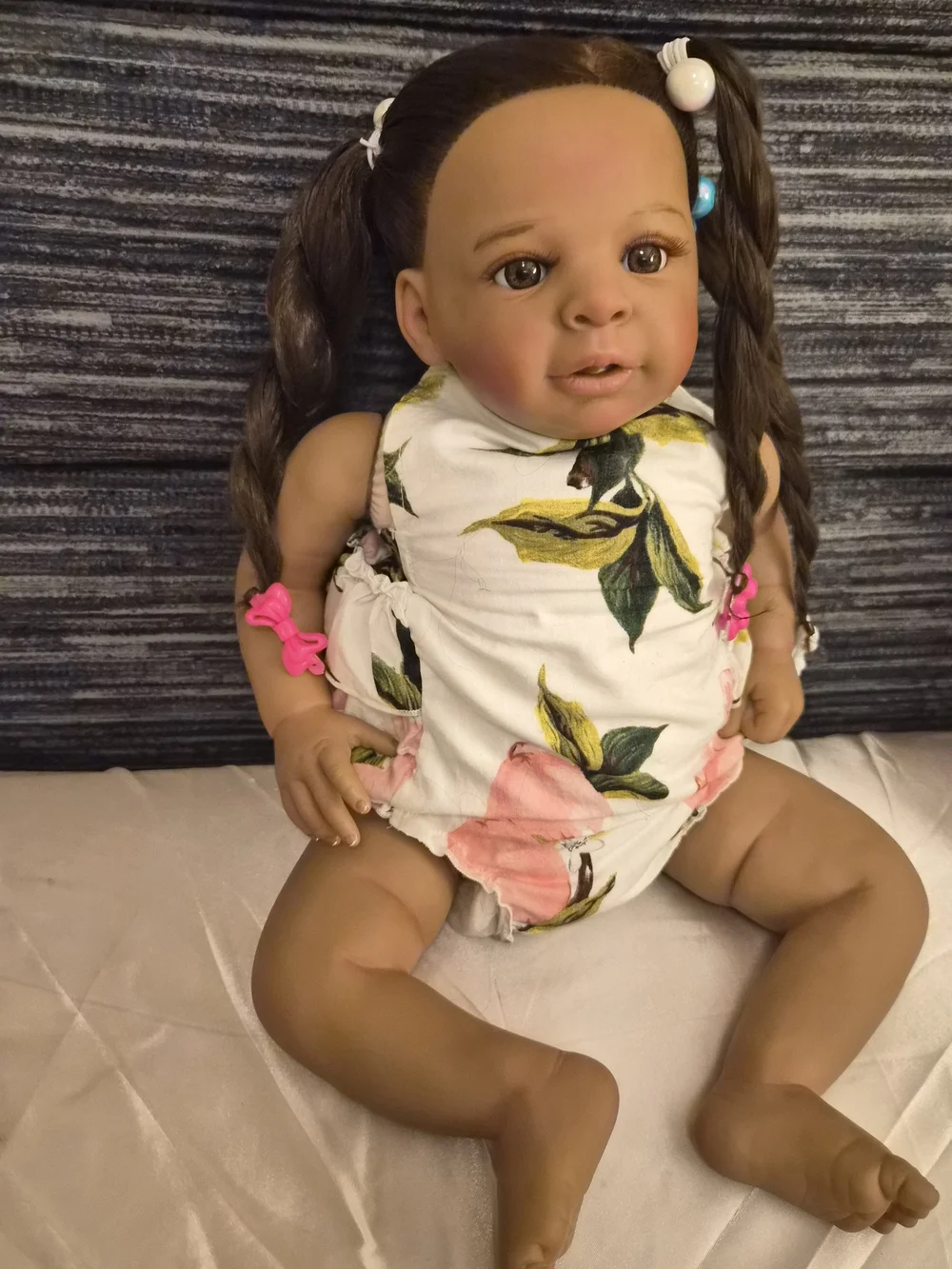 Reborn brown baby doll with pink and white floral outfit